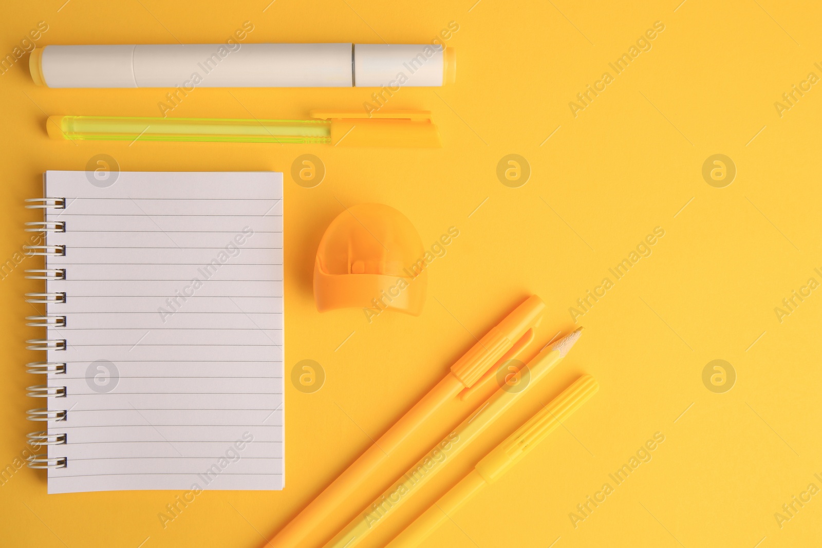 Photo of Flat lay composition with open notebook and different school stationery on yellow background, space for text. Back to school