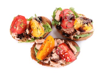 Delicious bruschettas with balsamic vinegar, tomatoes, arugula and tuna isolated on white, top view