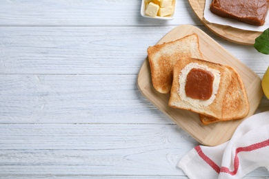 Photo of Toasts with delicious quince paste on white wooden table, flat lay. Space for text