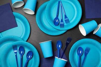 Photo of Flat lay composition with bright disposable tableware on black background