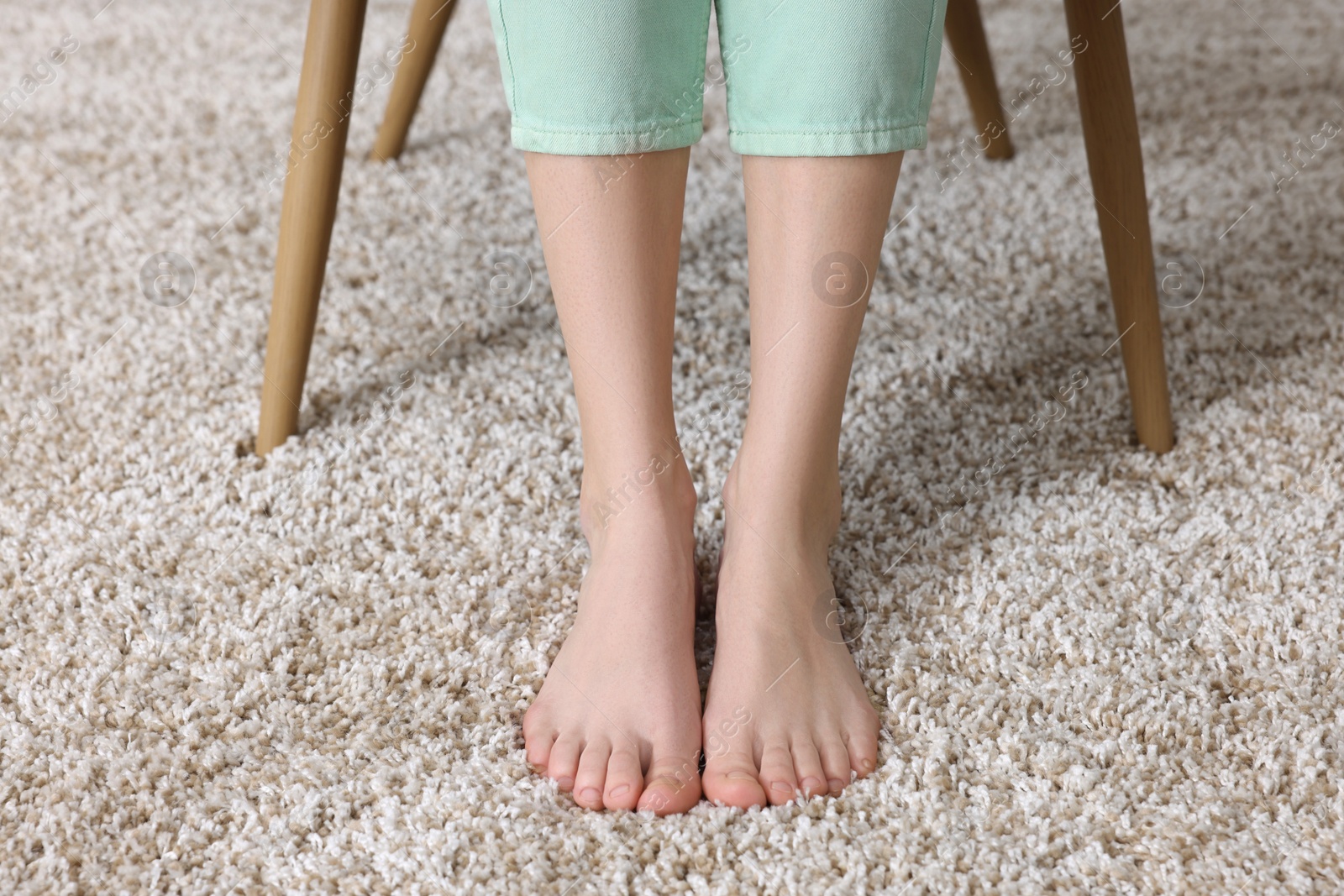 Photo of Woman on soft light brown carpet at home, closeup