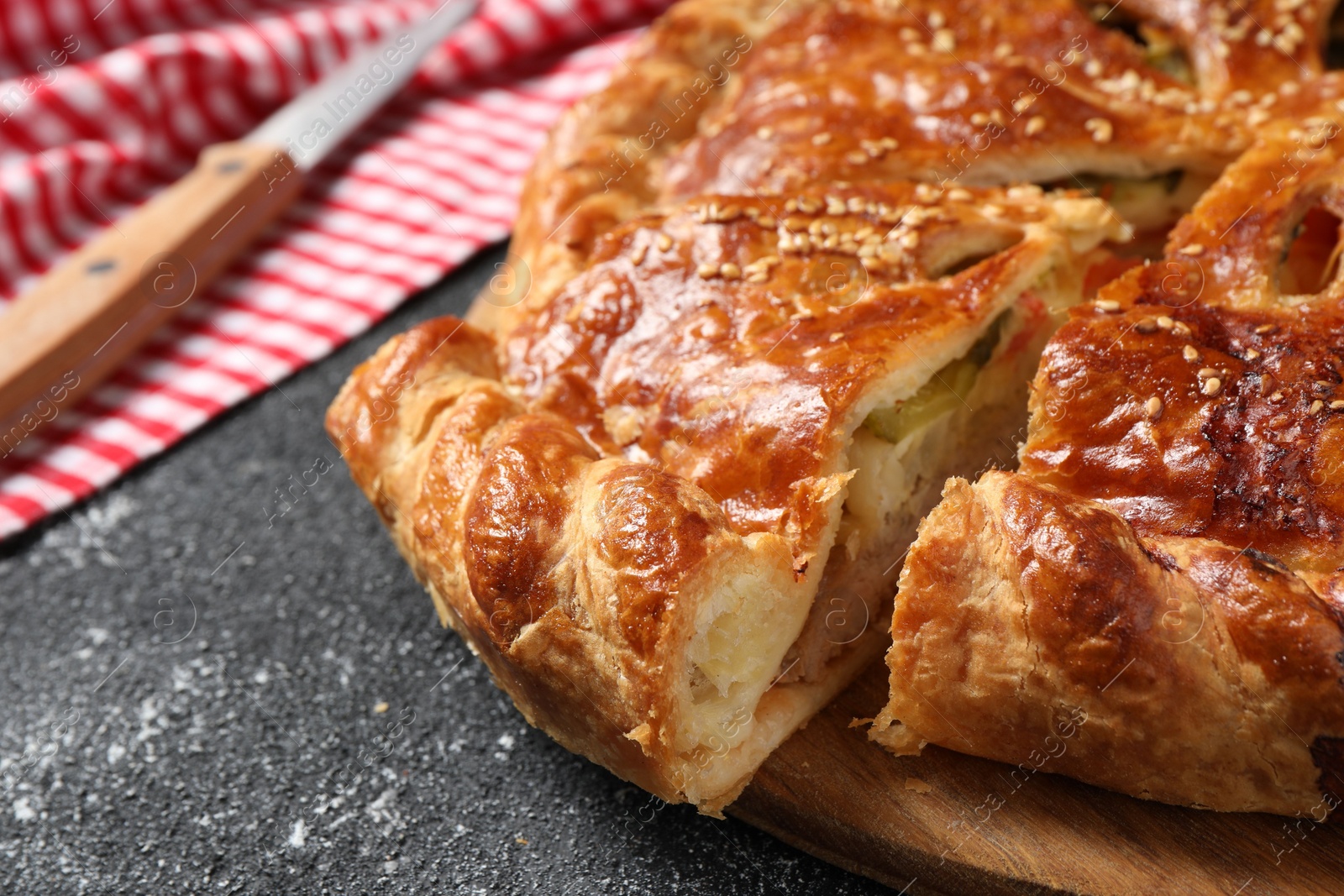 Photo of Cut delicious homemade pie on black table, closeup