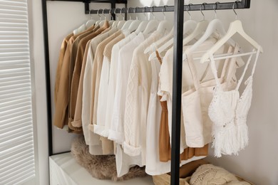 Photo of Rack with stylish women's clothes in dressing room