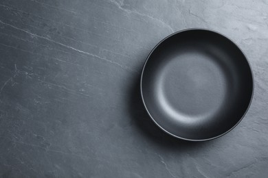 Photo of Empty clean ceramic bowl on grey table, top view. Space for text