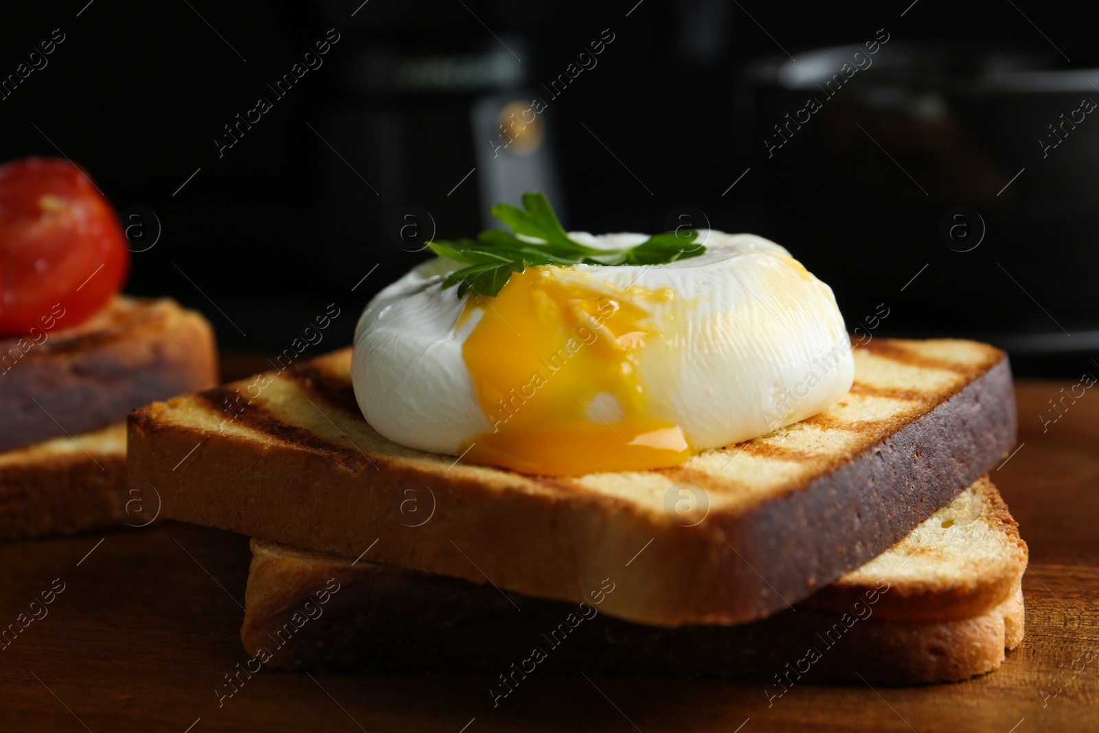 Photo of Delicious poached egg with toasted bread served on wooden board