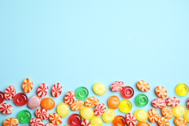 Photo of Flat lay composition with delicious colorful candies and space for text on color background