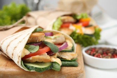 Photo of Delicious shawarma with chicken and fresh vegetables on table, closeup