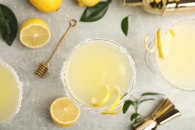 Photo of Delicious bee's knees cocktails and ingredients on light grey table, flat lay