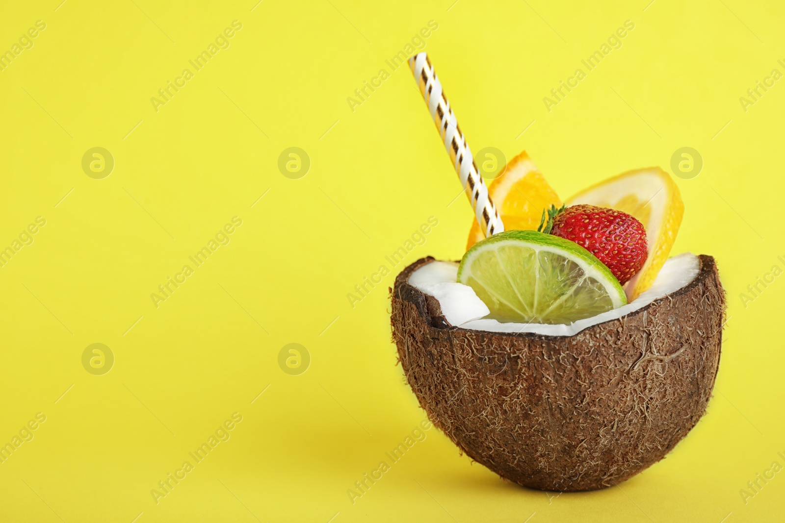 Photo of Summer refreshing cocktail in coconut on color background, space for text