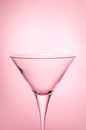 Photo of Elegant empty martini glass on pink background, closeup. Space for text