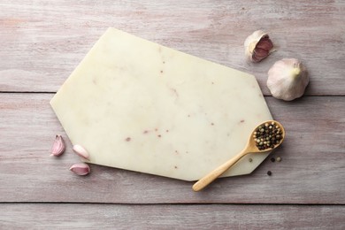 Photo of Cutting board, pepper and garlic on light wooden table, flat lay. Space for text