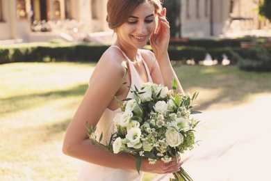 Photo of Gorgeous bride in beautiful wedding dress with bouquet outdoors