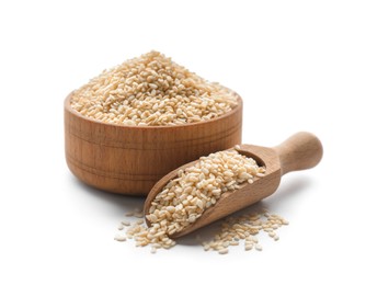 Photo of Wooden bowl and scoop with sesame seeds on white background