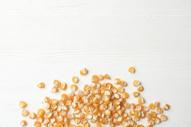 Photo of Raw dry corn seeds and space for text on white wooden background, flat lay. Vegetable planting
