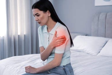 Image of Woman suffering from shoulder pain on bed at home