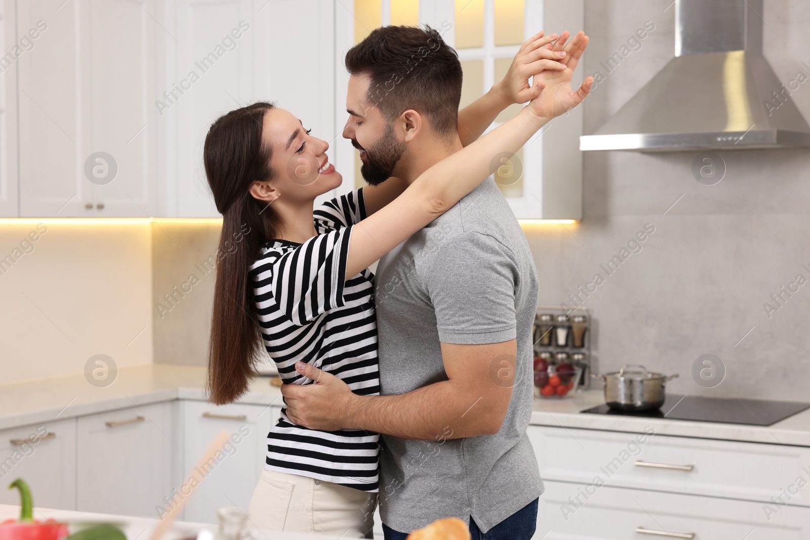 Photo of Lovely couple enjoying time together while cooking in kitchen