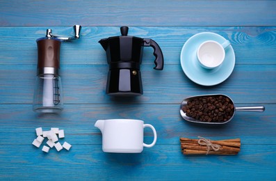 Photo of Flat lay composition with manual grinder and geyser coffee maker on light blue wooden background