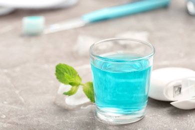 Photo of Glass with mouthwash on marble background. Teeth care