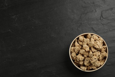 Photo of Dried soy meat on black slate table, top view. Space for text