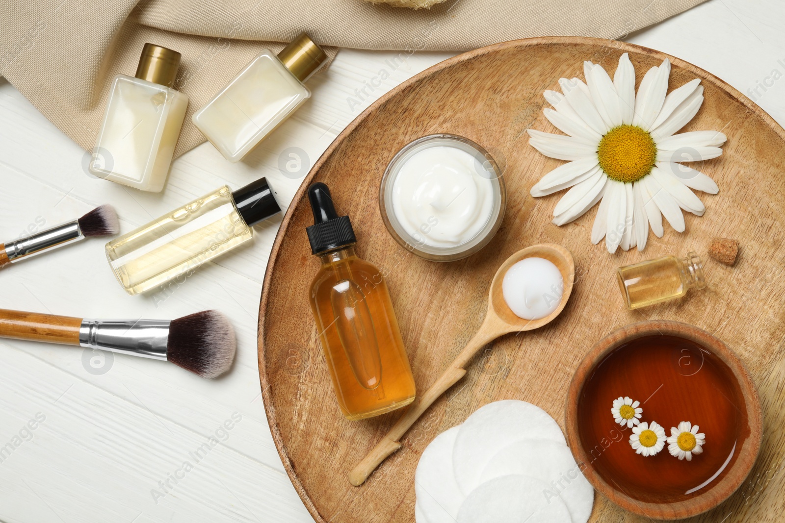 Photo of Flat lay composition with chamomile and cosmetic products on white wooden table