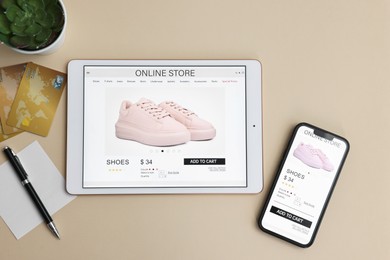 Photo of Online shopping. Flat lay composition with modern tablet and smartphone on beige background
