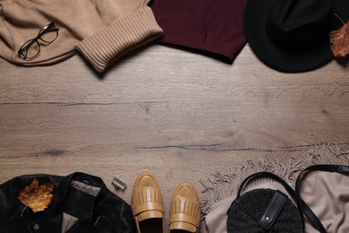 Photo of Flat lay composition with stylish clothes and accessories on wooden background, space for text