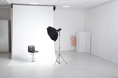 Photo of Photo studio interior with modern chair and professional lighting equipment