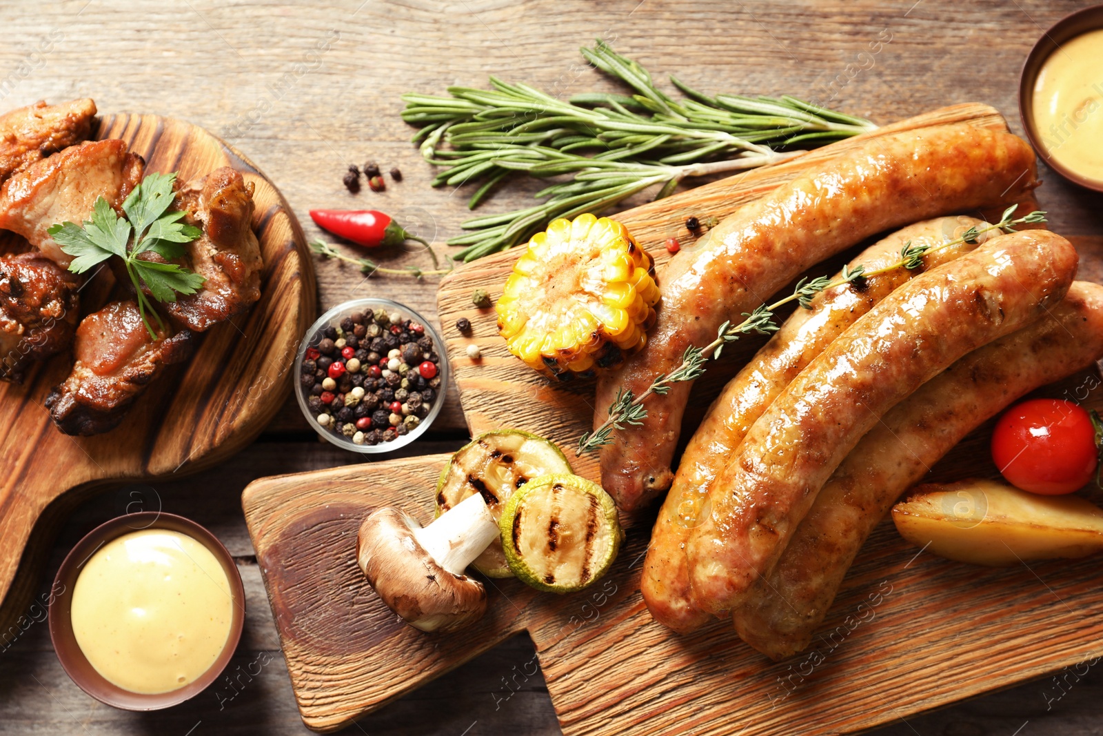 Photo of Delicious meal served for barbecue party on wooden table, flat lay