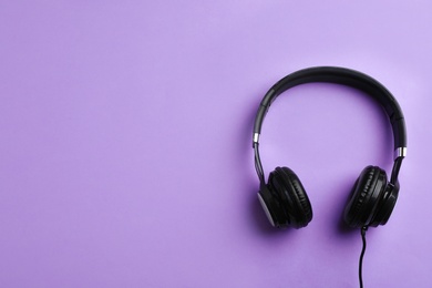 Photo of Stylish headphones on color background, top view. Space for text