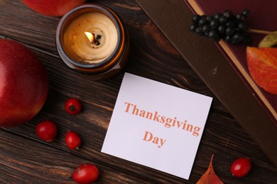 Photo of Thanksgiving Day. Flat lay composition with paper card and autumn leaves on wooden table