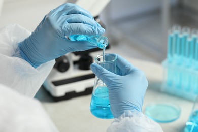 Photo of Scientist working with flasks in laboratory, closeup