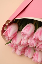Photo of Beautiful bouquet of fresh pink tulips on beige background, closeup