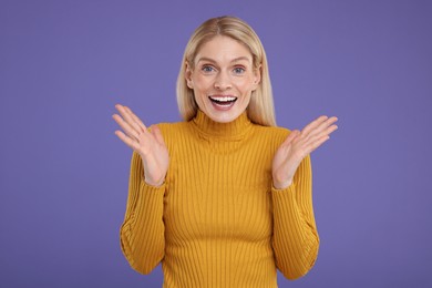 Photo of Portrait of happy surprised woman on violet background