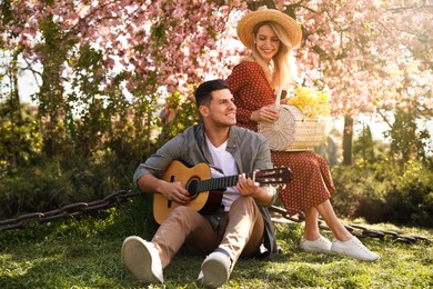 Lovely couple having picnic in park on sunny spring day