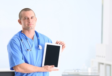 Photo of Portrait of medical assistant with stethoscope and tablet in hospital. Space for text