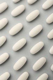 Photo of Vitamin pills on light grey background, flat lay. Health supplement
