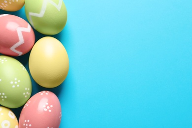 Photo of Beautiful painted Easter eggs on color background, flat lay. Space for text