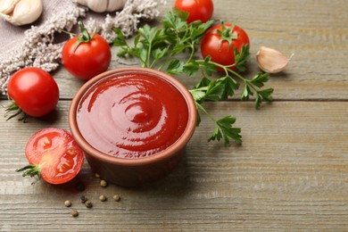 Photo of Tasty ketchup, fresh tomatoes, parsley and spices on wooden table. Space for text