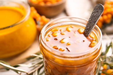 Photo of Delicious sea buckthorn jam in jar, closeup