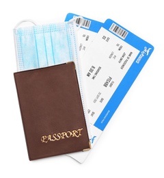 Photo of Passport, tickets and protective mask on white background, top view. Travel during quarantine