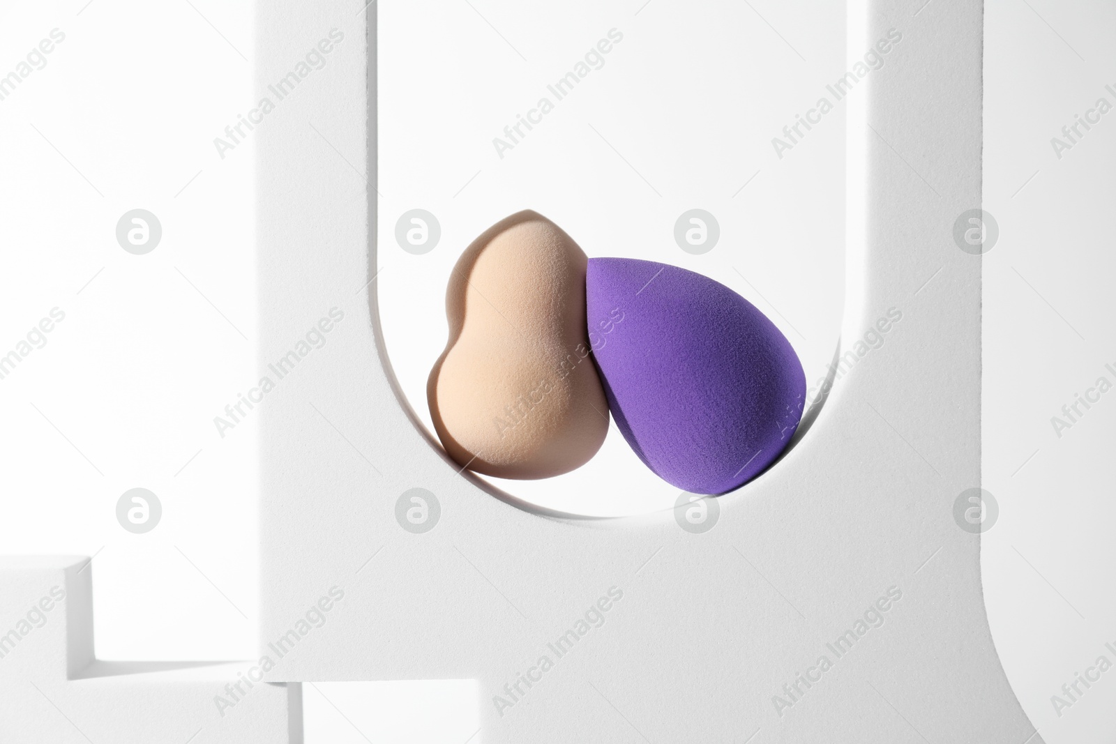 Photo of Stylish presentation of makeup sponges on white background