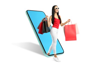 Image of Online shopping. Happy woman with paper bags walking out from smartphone on white background