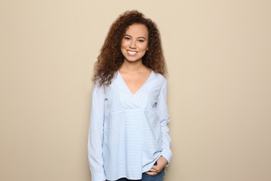 Photo of Young African-American woman with beautiful face on beige background