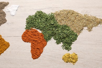 Continents of different spices on wooden table, flat lay