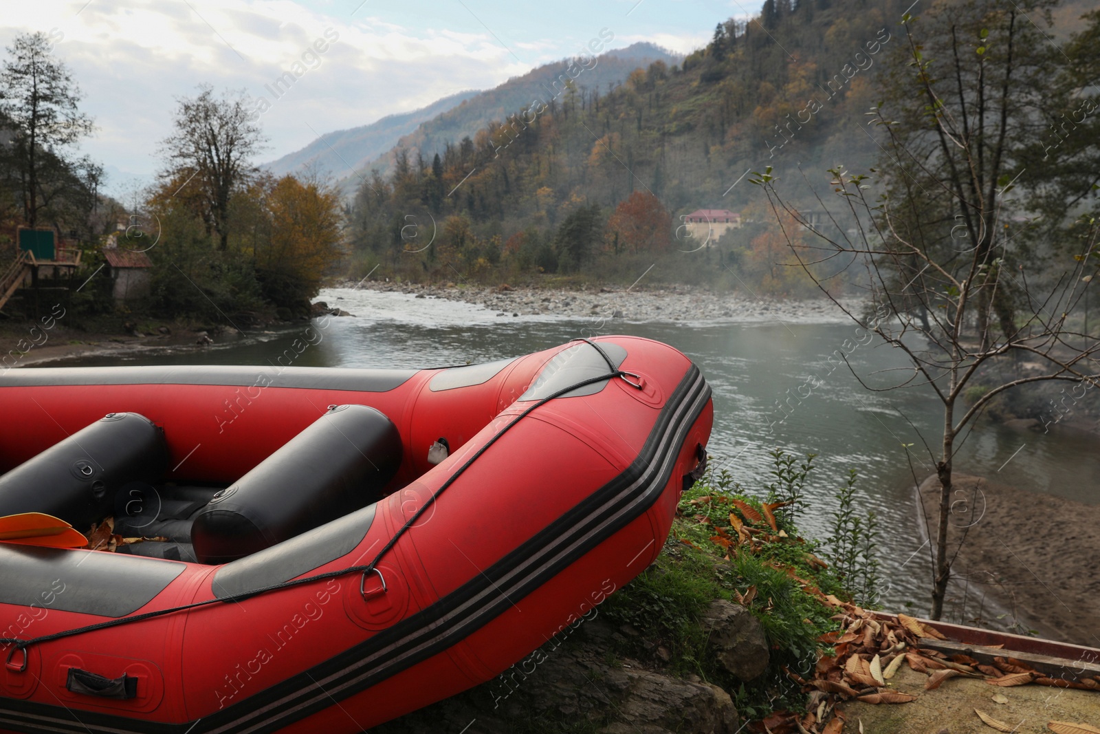 Photo of Inflatable rubber fishing boat near river in mountains