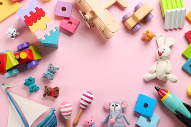 Photo of Frame made of different toys on pink background, flat lay. Space for text