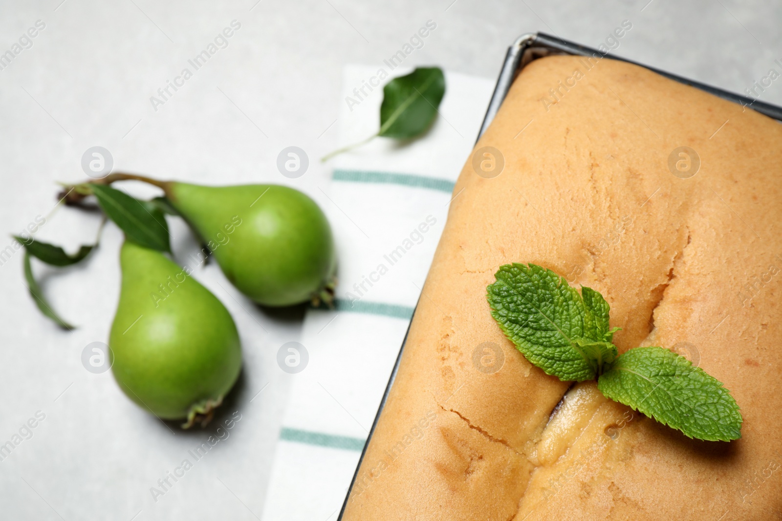 Photo of Tasty bread with mint and pears on light grey table, closeup. Homemade cake