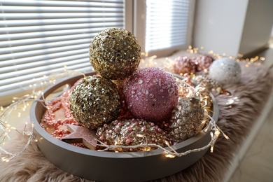 Photo of Beautiful Christmas tree baubles on window sill indoors, closeup