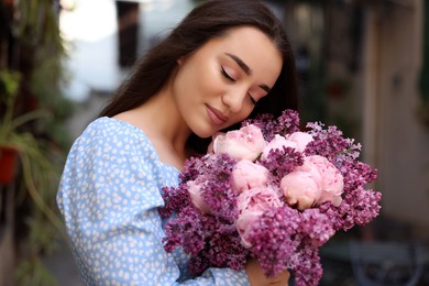 Beautiful woman with bouquet of spring flowers outdoors