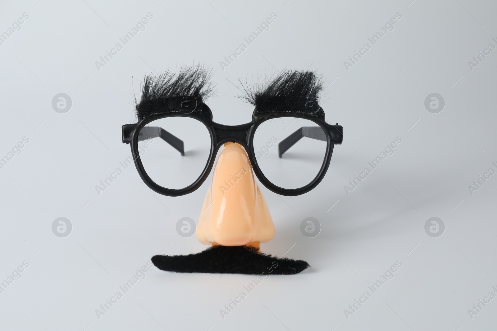 Photo of Funny mask with fake mustache, nose and glasses on light grey background